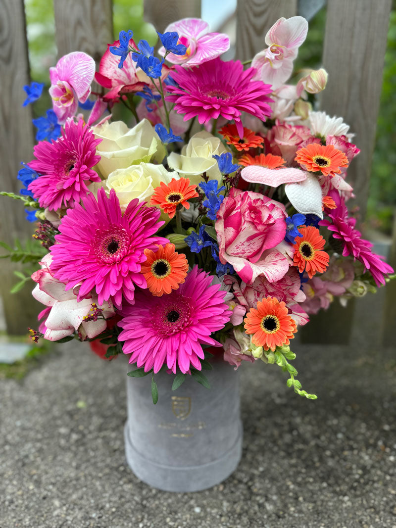 Flowerbox mit frischen bunten Blumen wie Gerbera, Orchideen und Rosen, ideal für festliche Anlässe und besondere Geschenke.