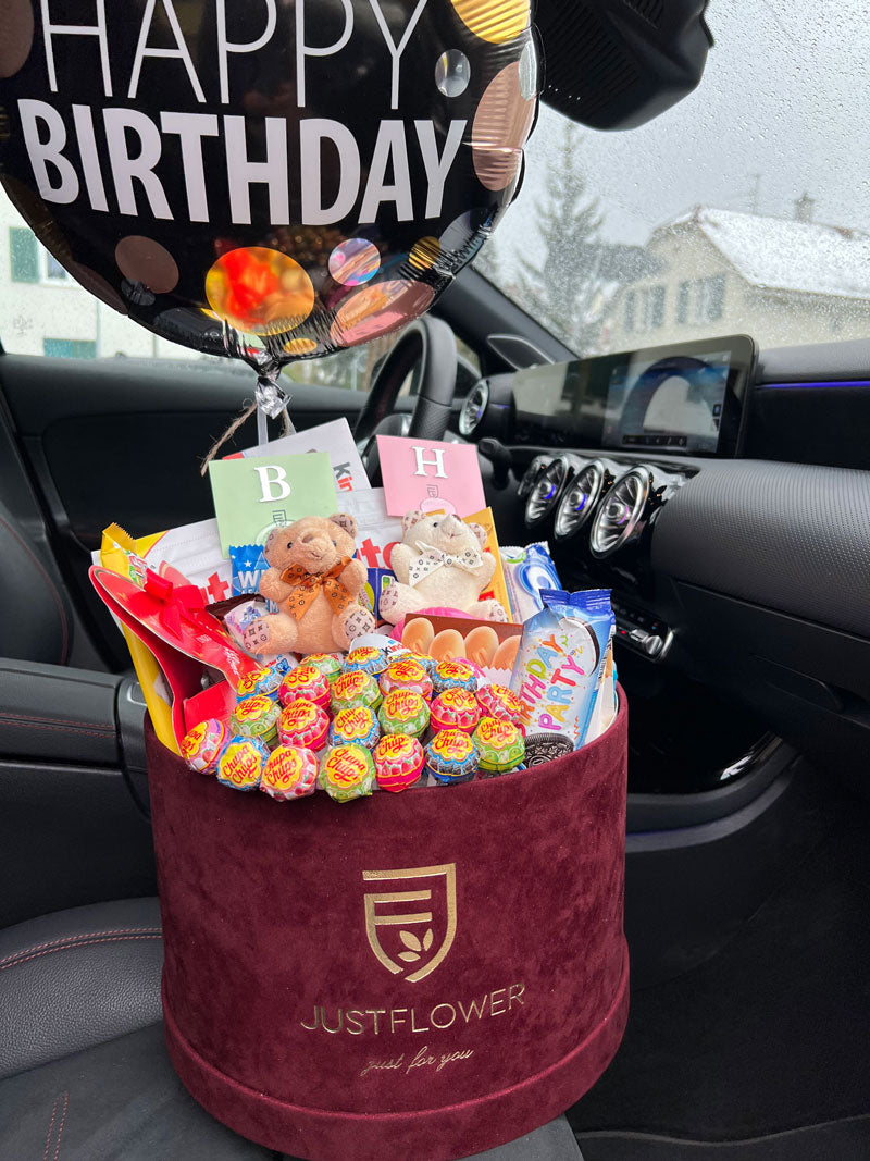 Geschenkbox zum Geburtstag mit Süssigkeiten, Kuscheltieren und einem ‘Happy Birthday’-Ballon, ideal für eine fröhliche Überraschung.