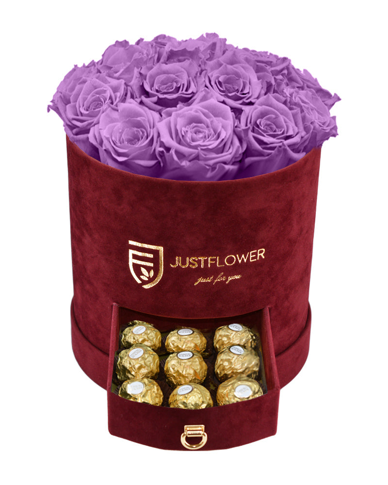 Rosenbox mit lilafarbenen Infinity Rosen – Burgunderfarbene Rosenbox mit konservierten ewigen Rosen und einer Schublade voller Ferrero Rocher. Bestellen Sie diese elegante Rosenbox bei JustFlower.ch für ein besonderes Geschenk.