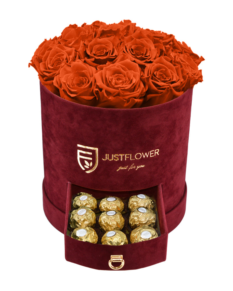 Rosenbox mit orangen Infinity Rosen – Burgunderfarbene Rosenbox mit konservierten ewigen Rosen und einer Schublade voller Ferrero Rocher. Bestellen Sie diese luxuriöse Rosenbox bei JustFlower.ch für ein besonderes Geschenk.