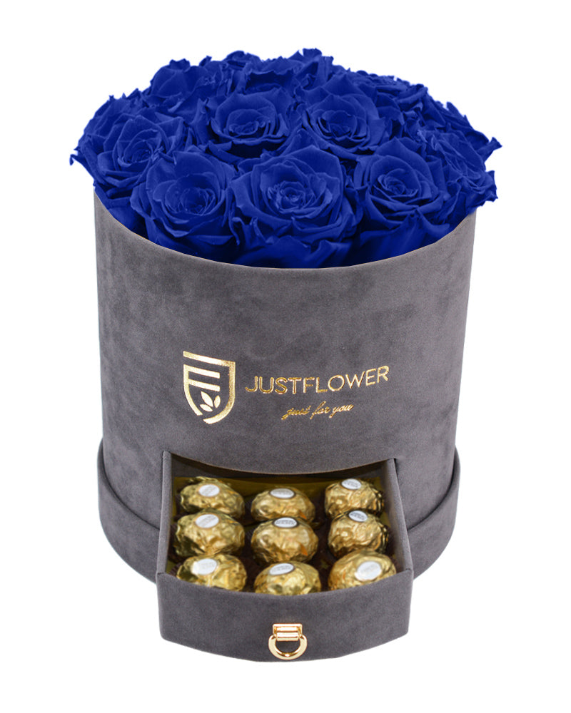 Rosenbox mit dunkelblauen Infinity Rosen – Graue Rosenbox mit konservierten blauen ewigen Rosen und einer Schublade voller Ferrero Rocher. Bestellen Sie diese luxuriöse Rosenbox bei JustFlower.ch für ein außergewöhnliches Geschenk.